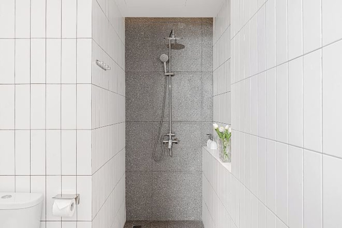 Un espacio de ducha estrecho con cabezal de ducha y ducha de mano.