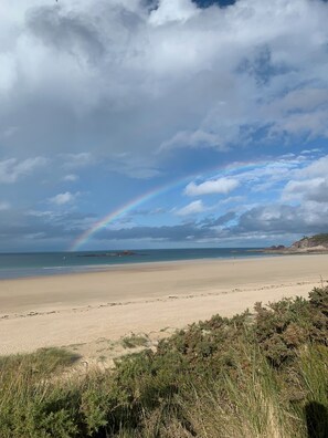 A beach with a rainbow, clear sky, and distant rocky formations. - VILLA GRAVELOUP Family Vacation Home, Close to the Ocean and the Beaches   (Erquy)