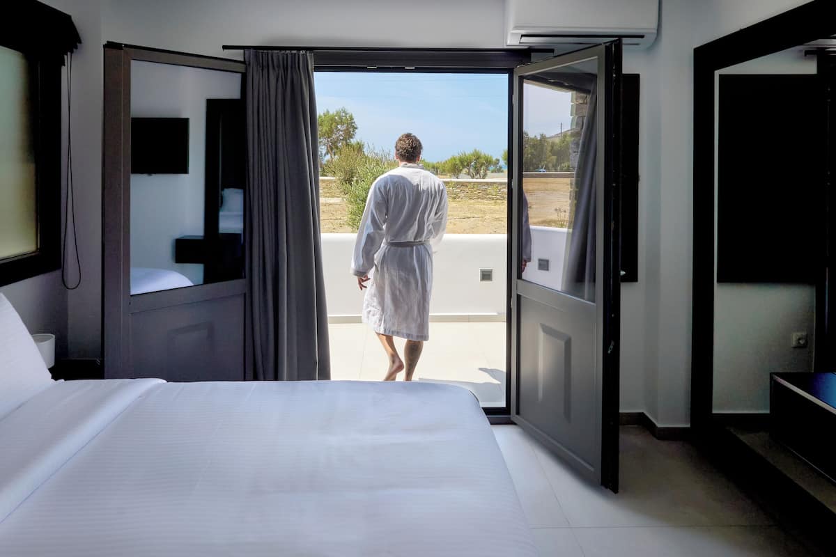Habitación de hotel con una cama grande, televisión y vistas al exterior.