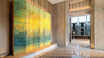 Experience the vibrant lobby area with a striking abstract painting and geometric tile design.