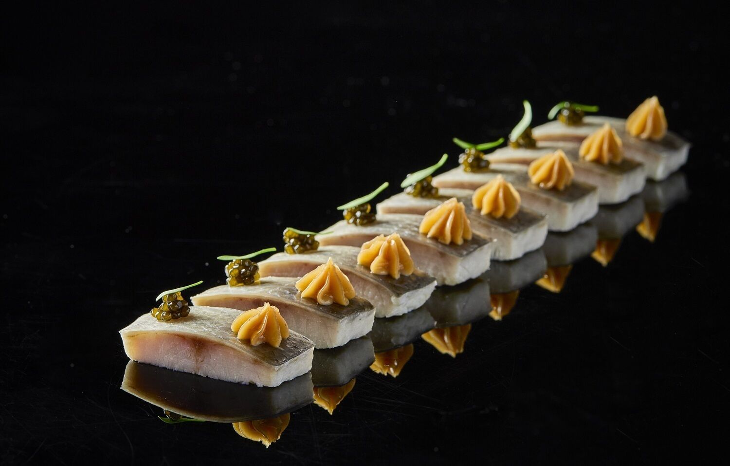 A series of neatly arranged food items on a reflective surface.