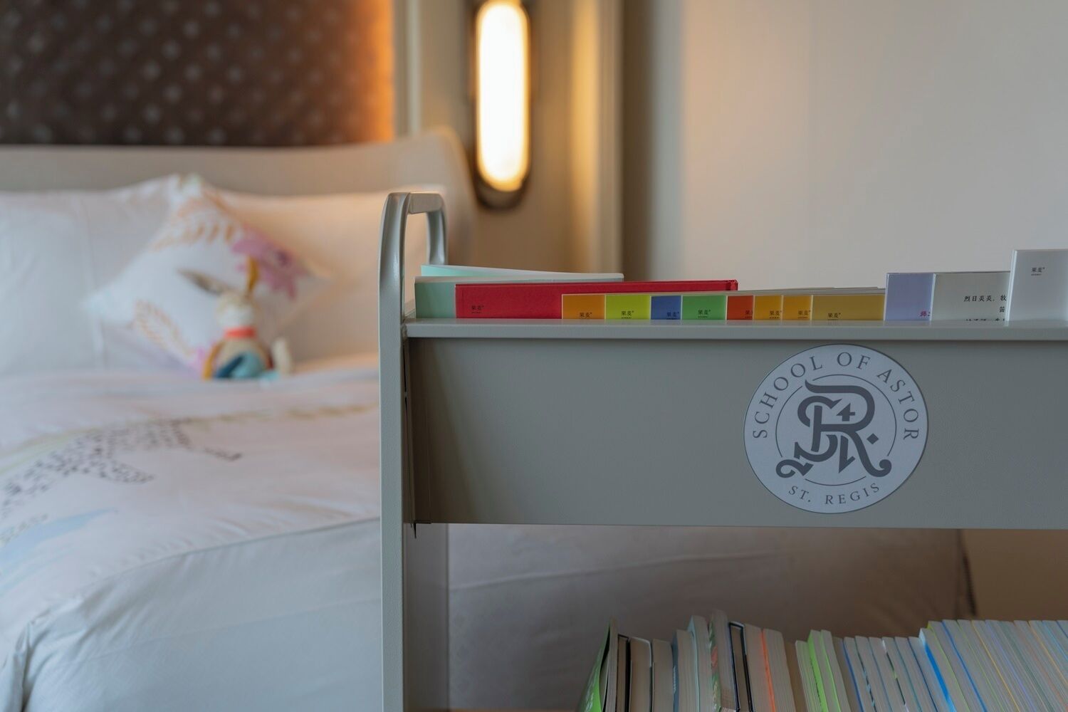 A neatly organized bookshelf with books and a logo of the School of Astrology.