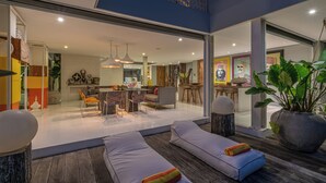 Un interior moderno con zona de comedor, cocina y asientos acolchados.