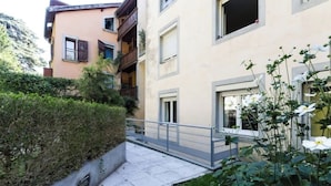 A residential building with balconies, a gated entrance, and a pathway leading to the entrance. - T3 in green Grenoble city center (Grenoble)