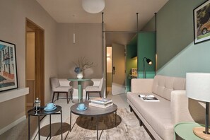 A modern living room with a sofa, two armchairs, a coffee table, and a small side table. There is a framed picture on the wall and a floor lamp. - M Village Hotel Lý Tự Trọng, a brand of Modern Village Lifestyle (Ho Chi Minh City)