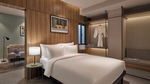 A modern hotel room with a wooden panel wall, a bed with white linens, a bedside table with a lamp, a framed picture on the wall, and a robe hanging on a rack. - M Village Hotel Lý Tự Trọng, a brand of Modern Village Lifestyle (Ho Chi Minh City)