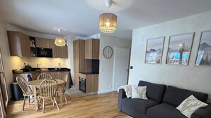 A modern apartment with a dining area, kitchen, living room, and a sofa set. - Magnificent new 60m2 apartment in an exceptional location! (Samoëns)