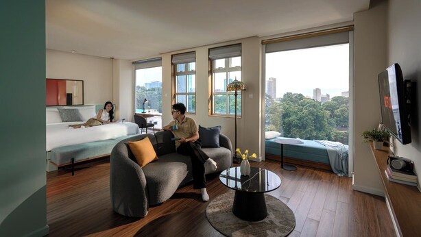 Una sala moderna con un sofá, una mesa redonda de centro y una cama.