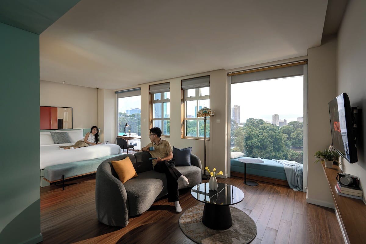 A modern living room with a sofa, a round coffee table, and a bed.