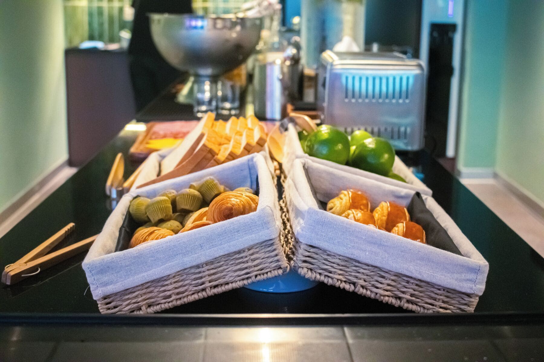 Une table de buffet avec divers plats présentés dans des paniers en osier.