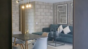 Un salon moderne comprenant un canapé, une table basse et un coin repas avec des chaises et une table.