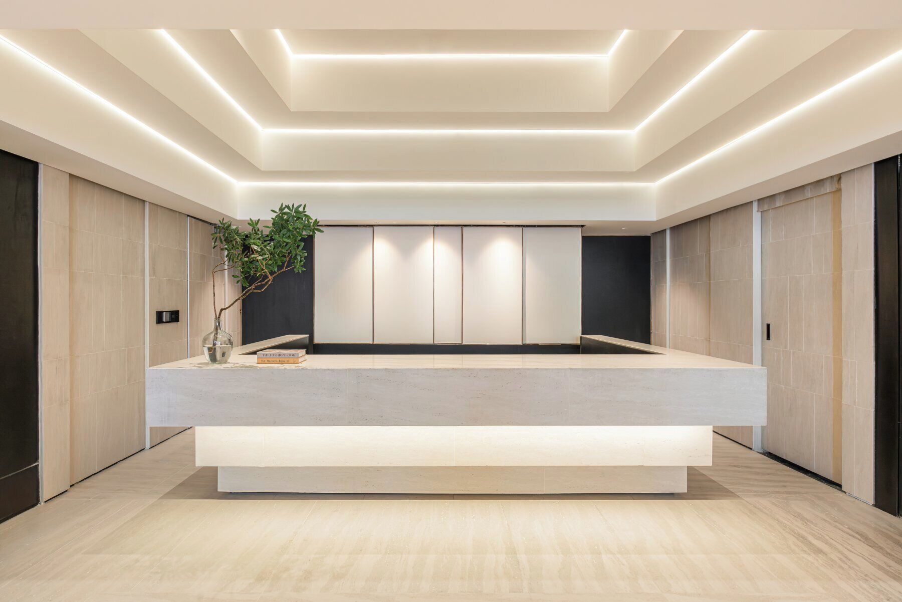 A modern interior with a central seating area, recessed lighting, and a minimalist design.