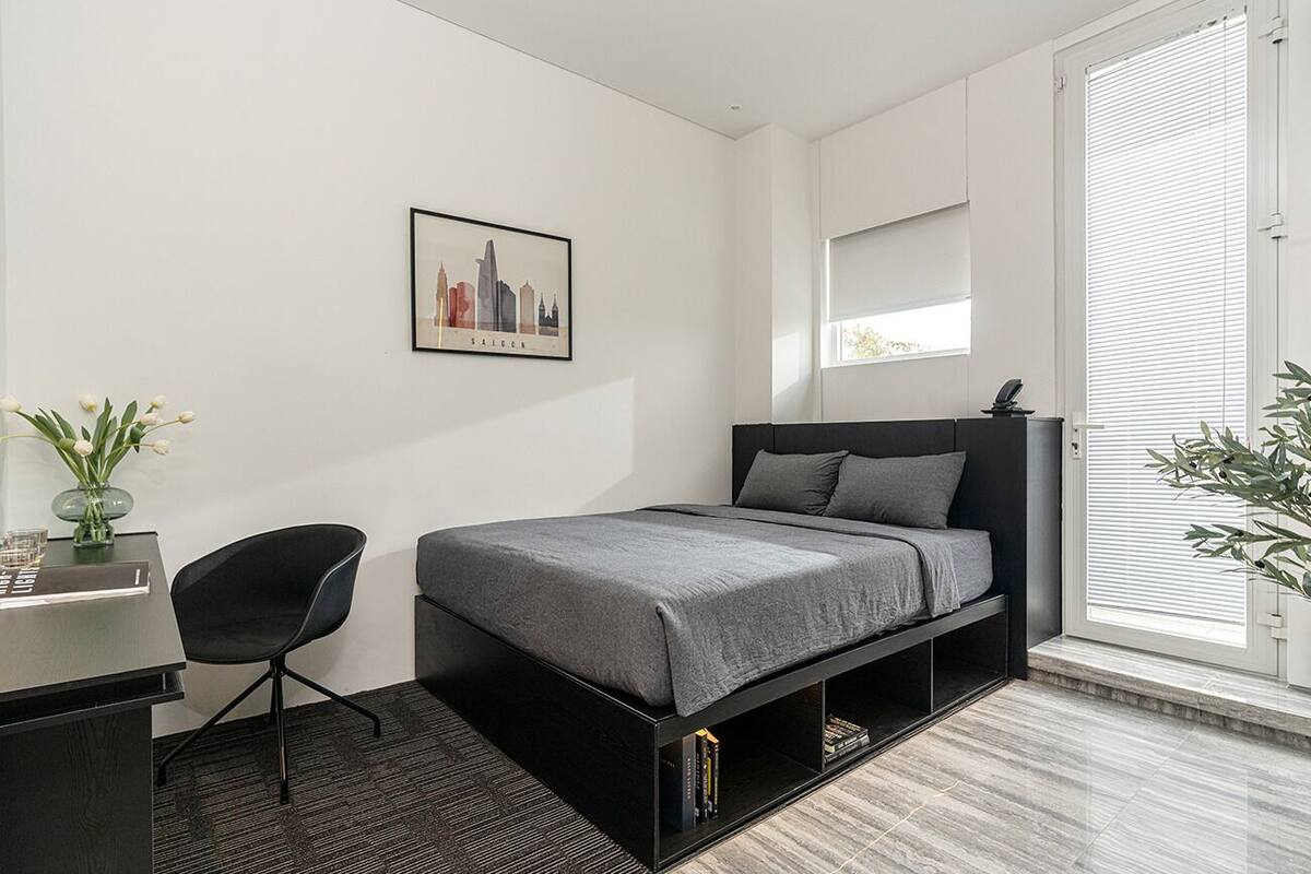 A modern bedroom with a bed, a desk, and a chair.
