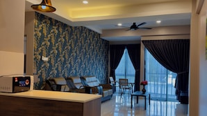 A modern living room with a central island, a sofa, a dining area, and a large window with curtains.