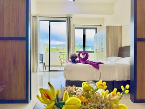 Una habitación de hotel con cama, balcón y vistas a la ciudad.