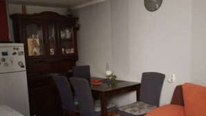 A compact living space with a dining area, a kitchenette, and a sofa. - Apartments Roma (Omis)