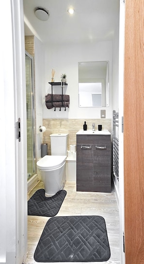 A modern bathroom with a toilet, sink, and vanity.