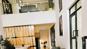 A spacious lobby with a reception desk, a staircase, and seating areas. - Hidden Hills Luxury Boutique Hotel (Nairobi)