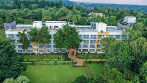 A multi-story hotel with a modern design, surrounded by lush greenery and a well-maintained lawn. - Hidden Hills Luxury Boutique Hotel (Nairobi)