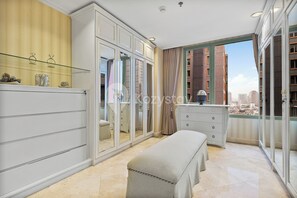 A modern bedroom with a large window, a vanity with a mirror, and a bench. - Brassia by Kozystay - Thamrin (Jakarta)
