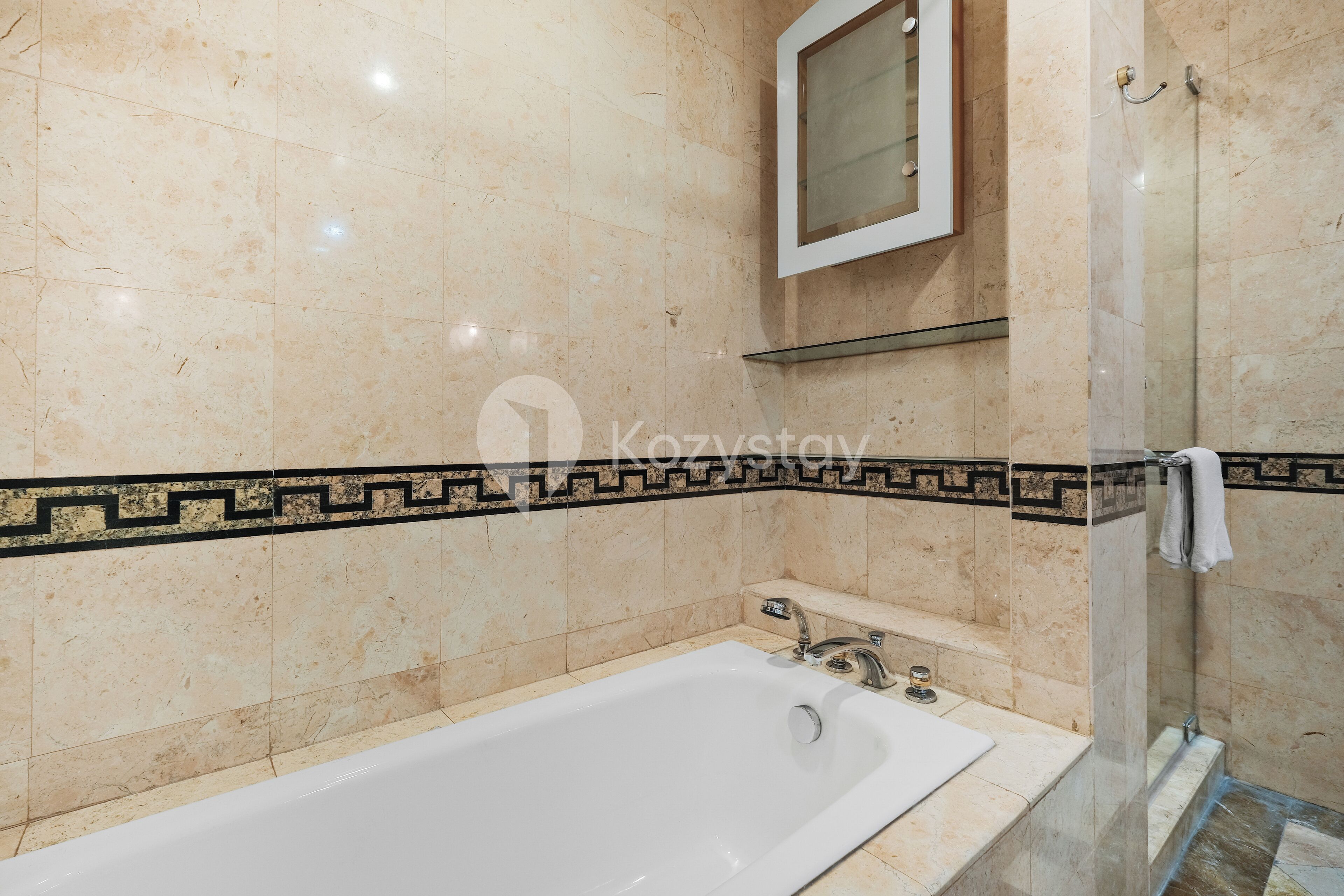 A bathroom with a bathtub, a glass shower enclosure, and a vanity with a mirror.