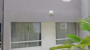 Un edificio con due finestre rotonde e un portone con una finestra.