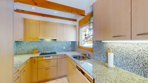 Una cucina moderna con piani in granito, mobili in legno e una finestra che lascia entrare luce naturale.