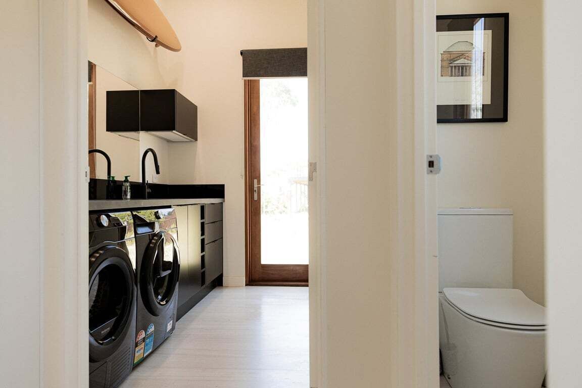 A laundry room with a washing machine and dryer, a sink, and cabinets.
