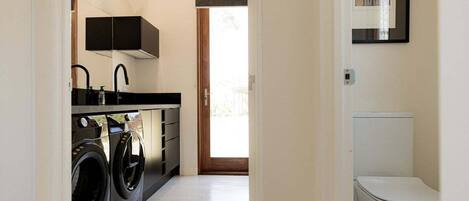 A laundry room with a washing machine and dryer, a sink, and cabinets.