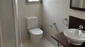 Un baño con inodoro, lavamanos y ducha.