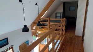 A wooden staircase with a loft bedroom above. - Chambre et Table d'Hôtes (Campan)