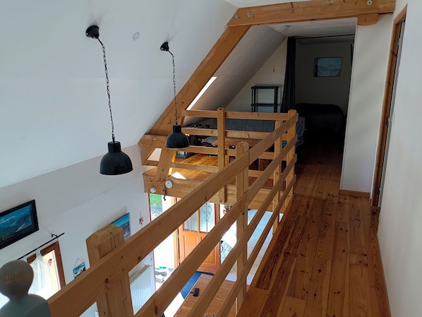 A wooden staircase with a loft bedroom above.