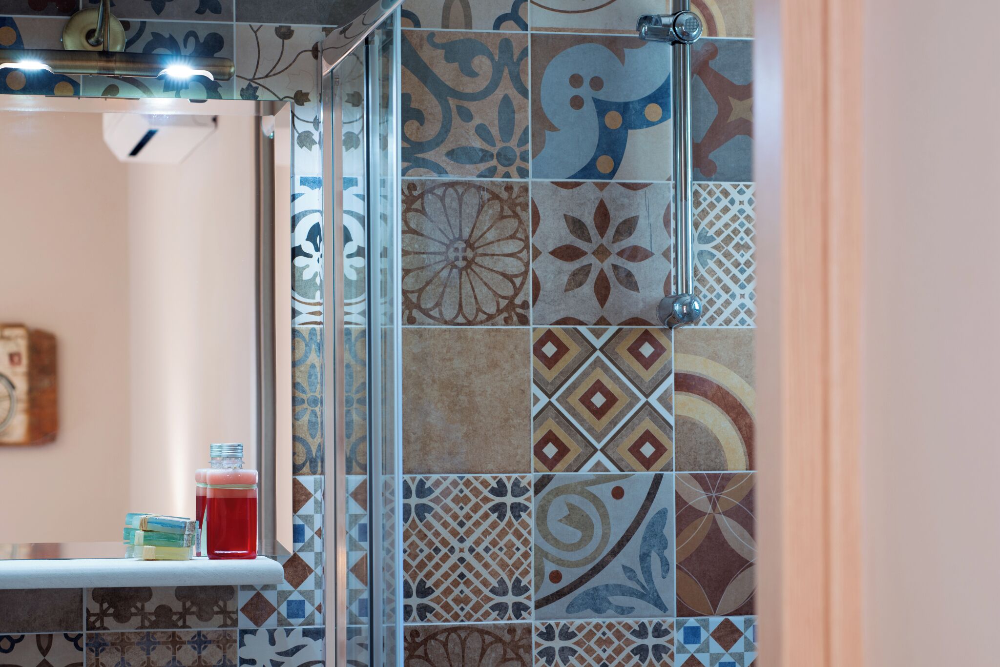 A bathroom with a tiled shower area and a shelf with toiletries.