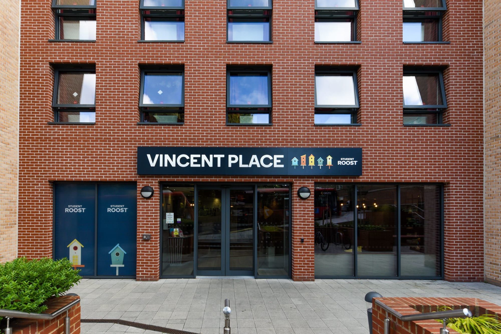 A brick building with a sign reading 'VINCENT PLACE STUDENT ROOST'.