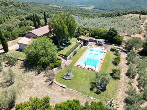 An aerial view of a property with a swimming pool, stone pathway, and surrounding greenery. - Luxury stone house, large private pool and stunning seaview, 3 golf courses nearby (Monterotondo Marittimo)