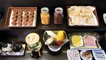 Een buffet met diverse etenswaren, zoals koekjes, granola, brood en verschillende soorten spreads en dips.