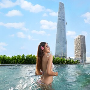 Una persona en una piscina con un paisaje urbano al fondo.