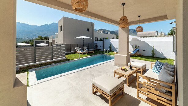 A modern outdoor pool area with lounge chairs, a wooden table, and a sofa. - KS2 Exclusive Luxury Villa with 2 Bedrooms, Private Pool, BBQ &Outdoor Dining (Asprouliani)
