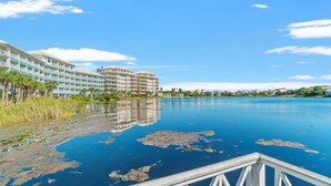Ein Hotel mit mehreren Etagen, Blick auf das Wasser und einem Anlegesteg.