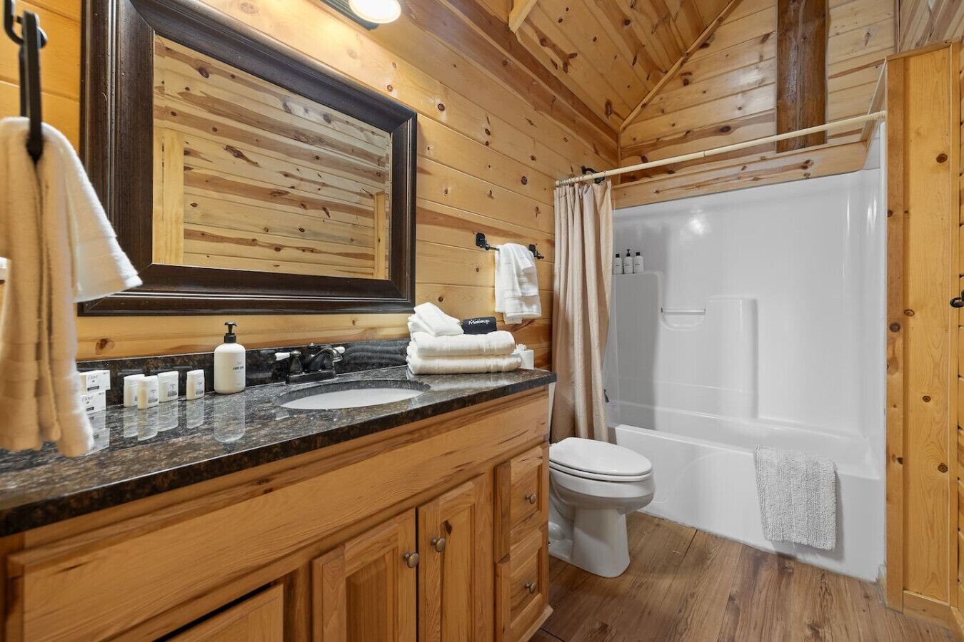 Bagno di una casetta di legno con lavandino, WC e doccia.