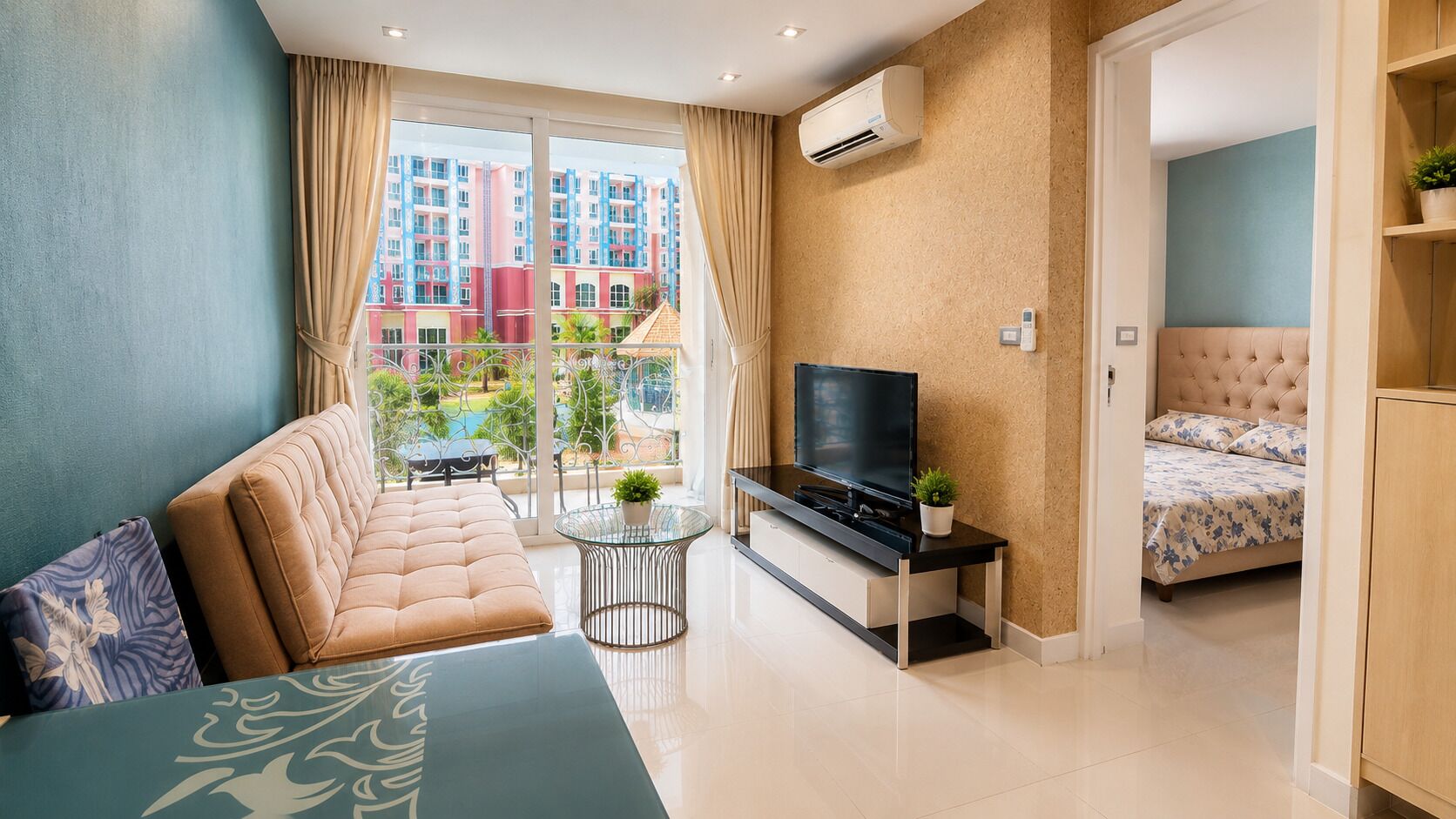 A modern hotel room with a sofa, a TV, a small table, and a bed.