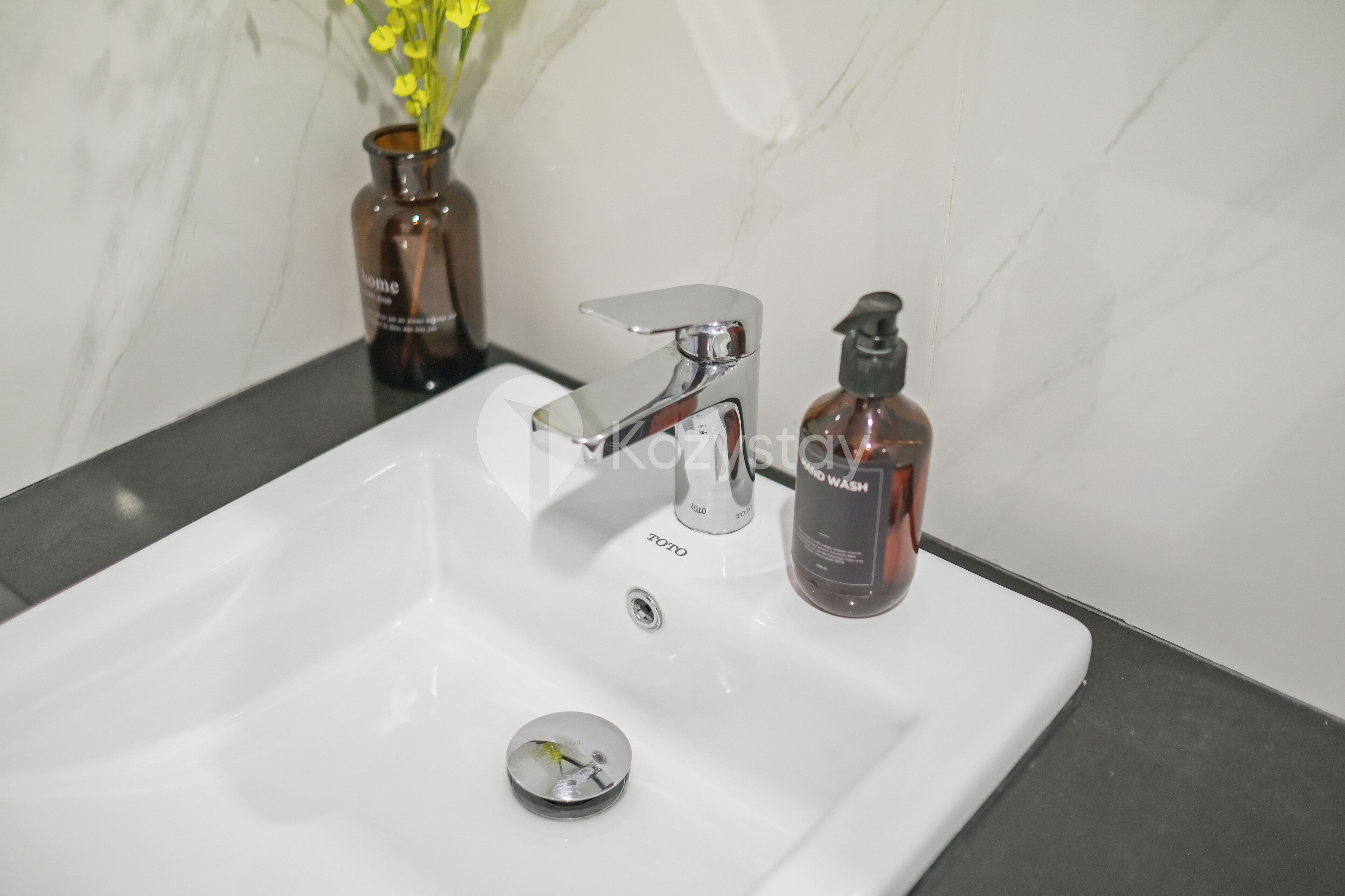 A bathroom sink with a modern faucet and a soap dispenser.
