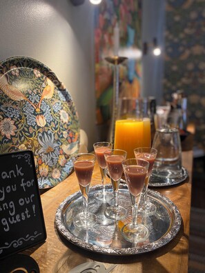 Enjoy a refreshing drink at our casual dining area, where a pitcher of orange juice and glasses of a fruity beverage await.