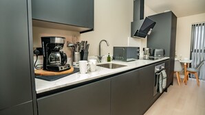 A modern kitchen with a coffee maker, microwave, and sink.