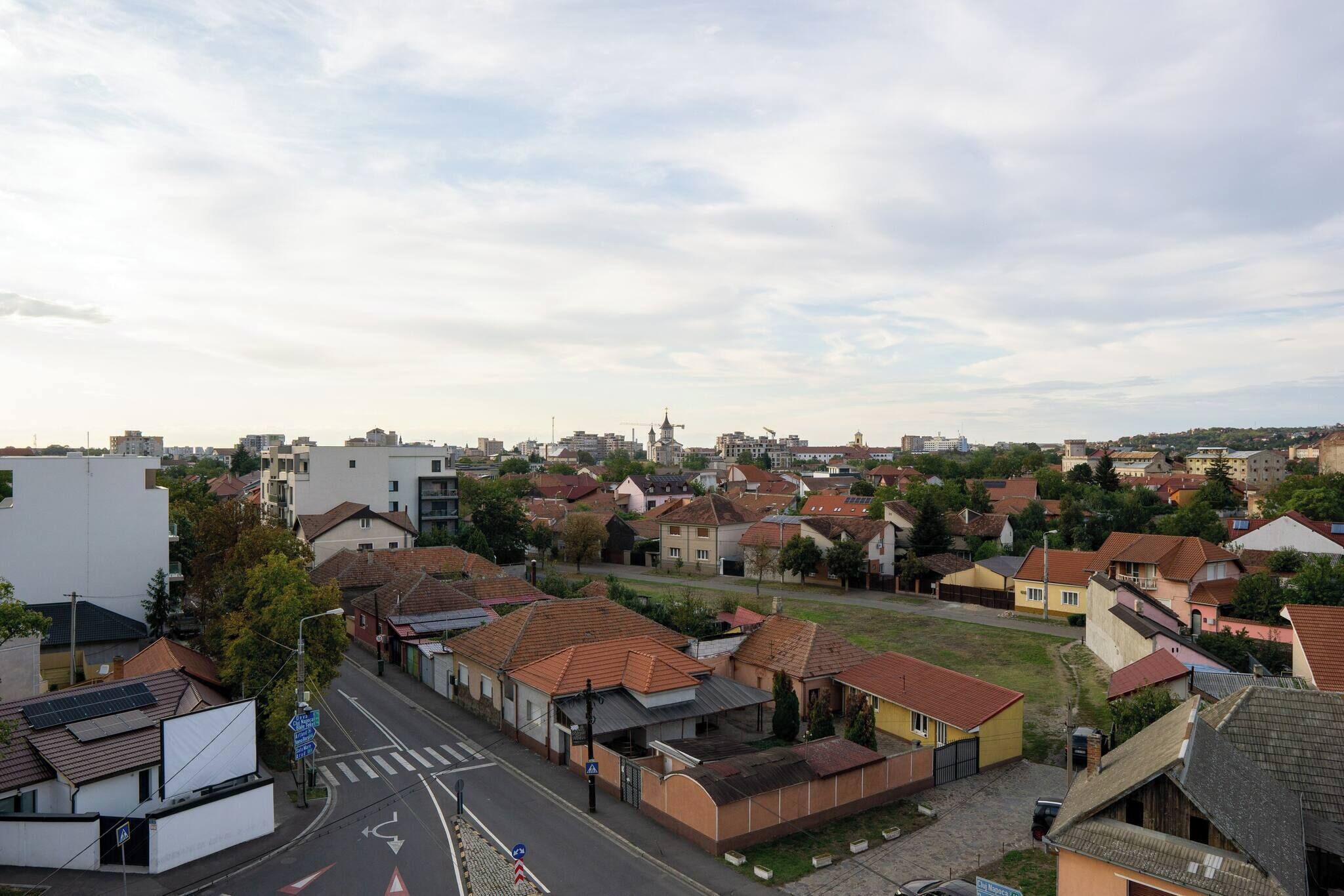 Ein Wohngebiet mit Häusern, einer Straße und einem entfernten Turm.