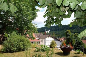 Ein Wohngebiet mit Häusern, einem großen Baum und einer Feuerstelle im Vordergrund.