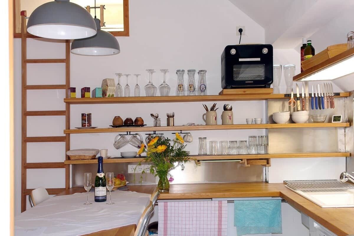 Eine Küche mit Holzböden, einem Toaster und einem Esstisch mit einem Blumenstrauß.