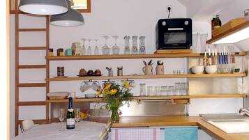 Eine Küche mit Holzböden, einem Toaster und einem Esstisch mit einem Blumenstrauß.