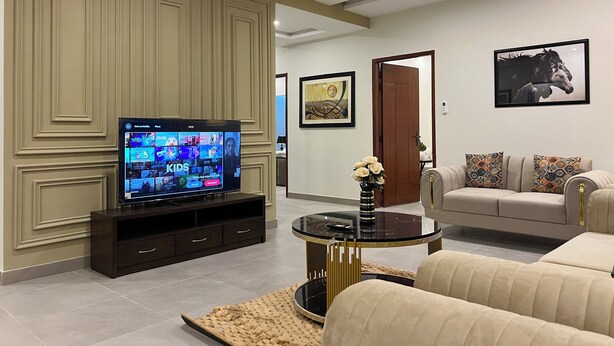 A living room with a TV, sofa, and coffee table.