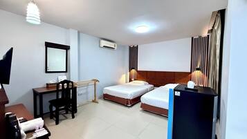 Une chambre d’hôtel avec deux lits, un bureau avec une chaise, une télévision et un mini-bar.